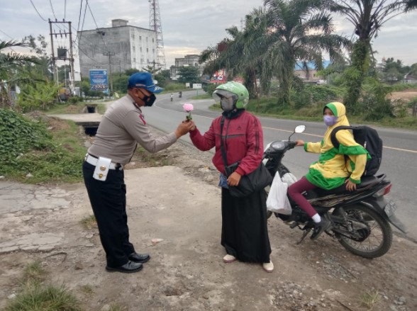 Dipimpin Ipda Wahidin, Satlantas Polres Batubara Berbagi Setangkai Bunga Kepada Para Guru