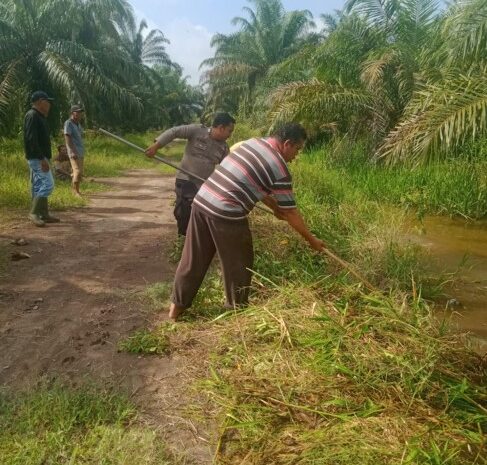 Bhabinkamtibmas Polsek Lima Puluh Gotong Royong Bersama Warga Bersihkan Jalan Desa