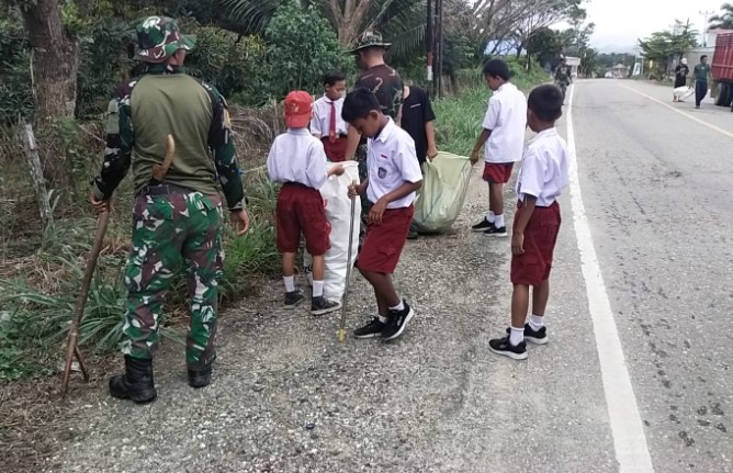  Anggota Koramil 1311-05/Mori Atas Bersama Anak Pramuka Kerja Bakti Bersihkan Jalan Trans Sulawesi Desa Lembontonara