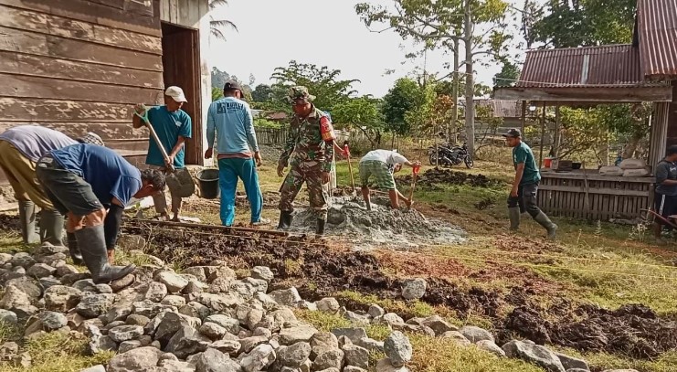  Babinsa Koramil 1311-08/Soyo Jaya Bantu Warga Bangun Fondasi Rumah di Desa Malino