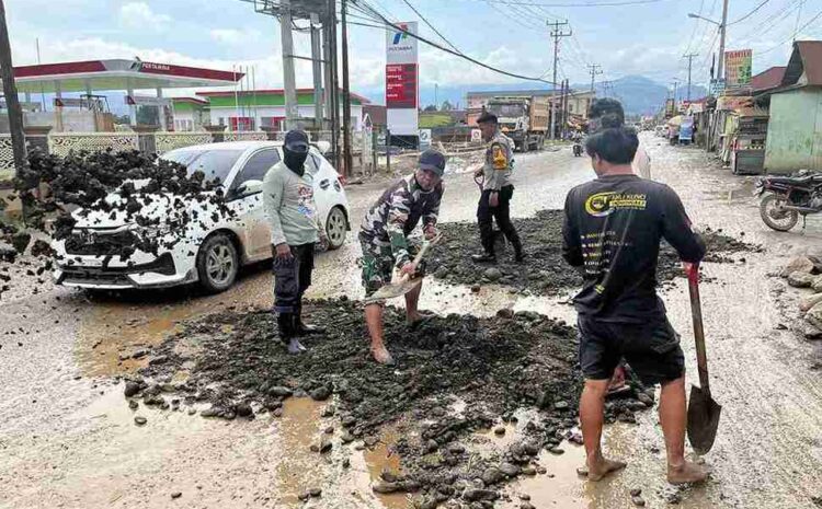  Babinsa dan Bhabinkamtibmas Bersama Warga Timbun Jalan Rusak di Desa Bahodopi